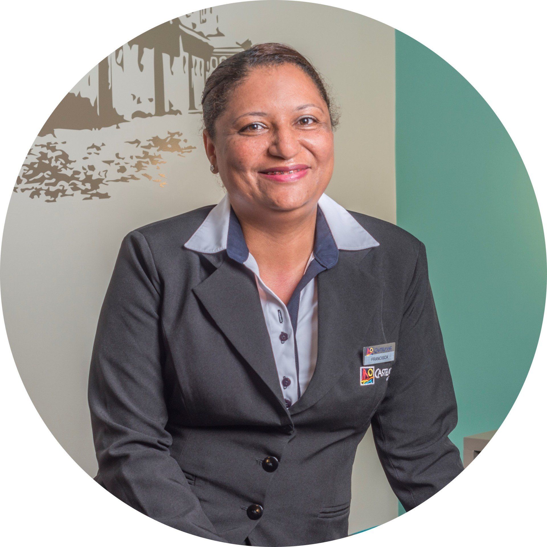 Mulher profissional de blazer escuro sorrindo em um ambiente de escritório.