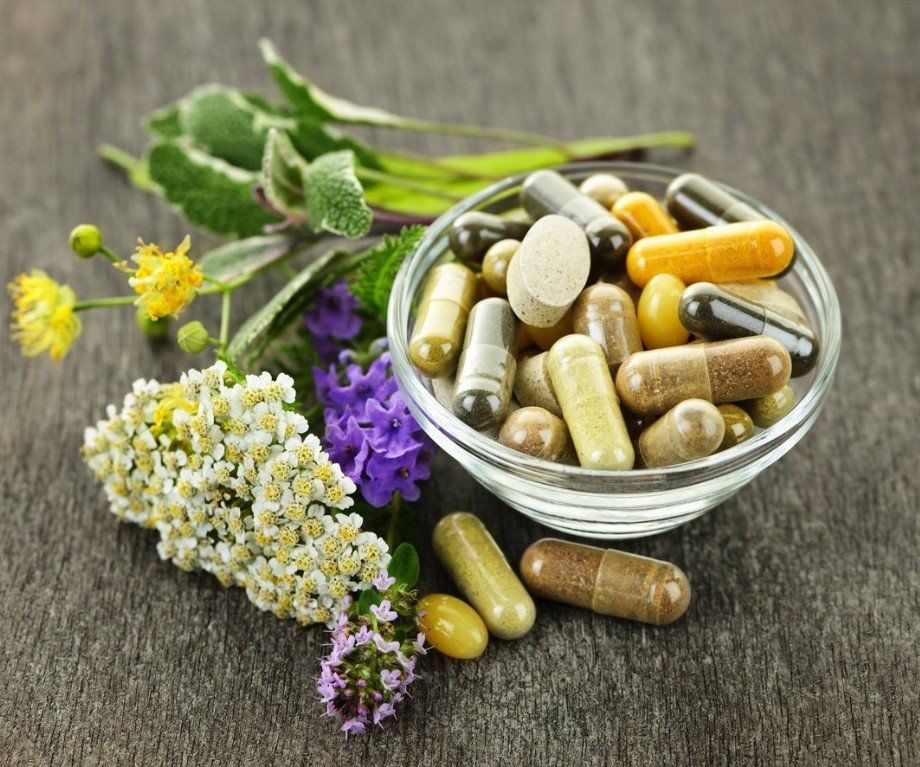 a bowl of pills and flowers on a table.