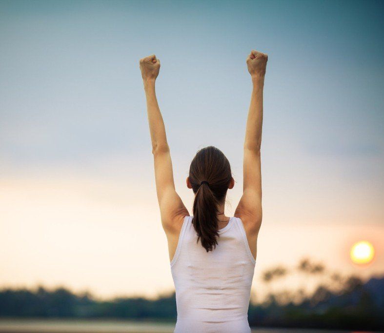 a woman is standing with her arms in the air .