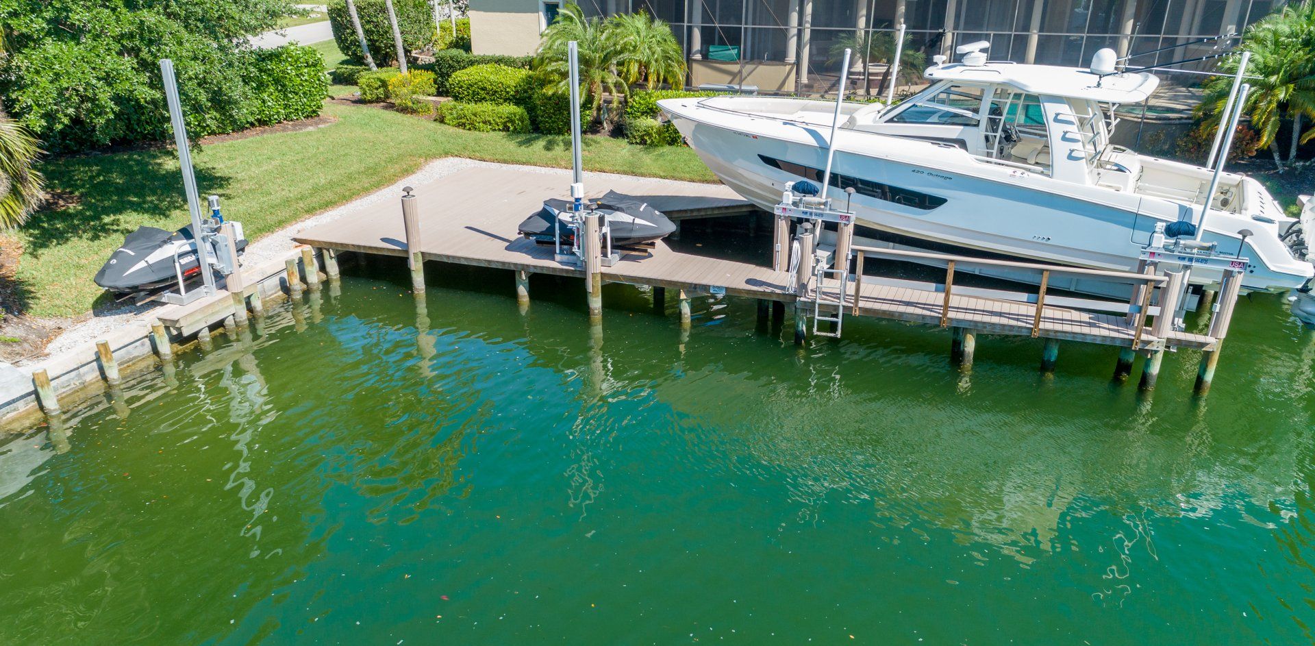 Small Boat Beside a Yacht — Marco Island, FL — Collier Seawall & Dock