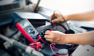 mechanic testing electrical system in car