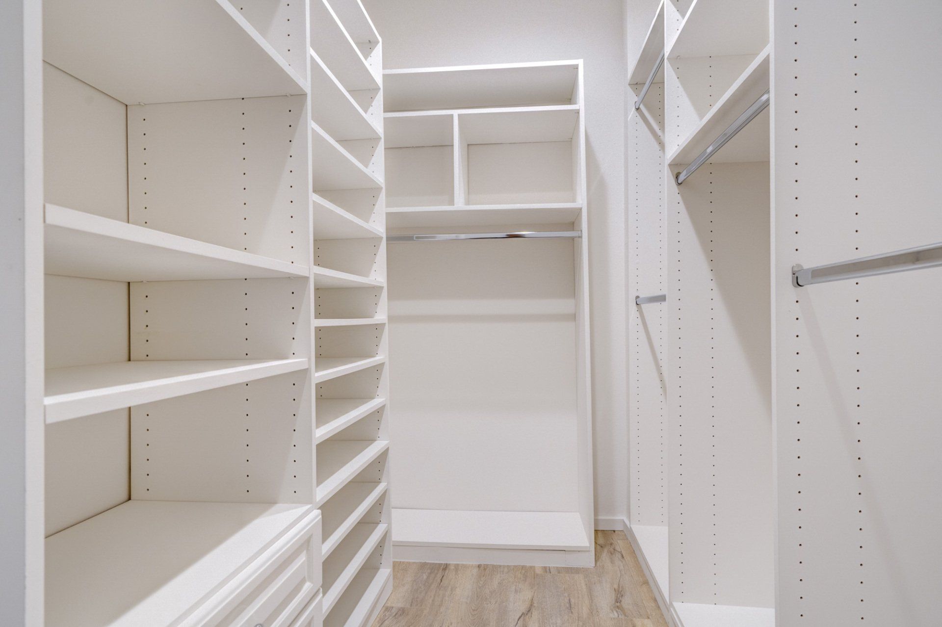 Interior view of large walk in closet with built in shelving on one side