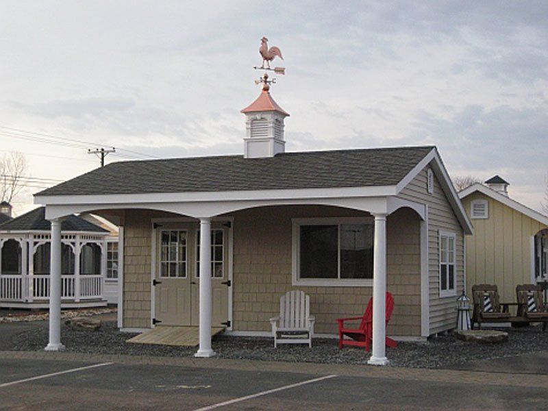 A small house with a weather vane on top of it