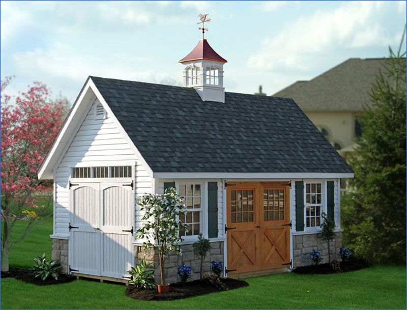 A shed with a weather vane on top of it