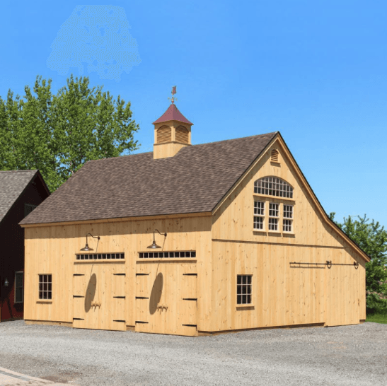 A large wooden barn with a clock tower on top