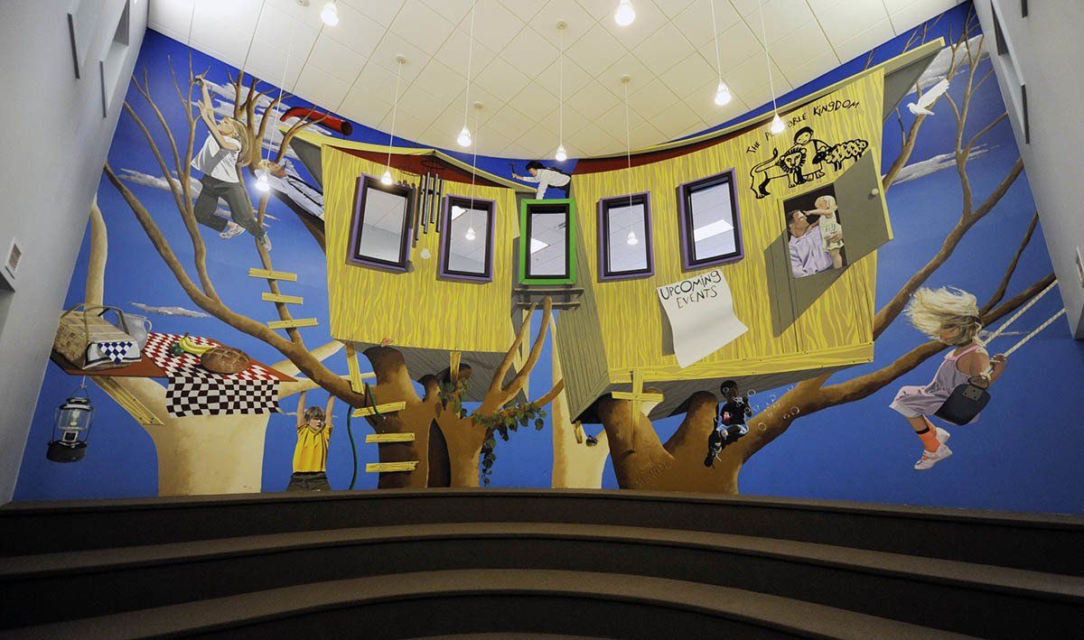 A tree house is hanging from the ceiling of a building