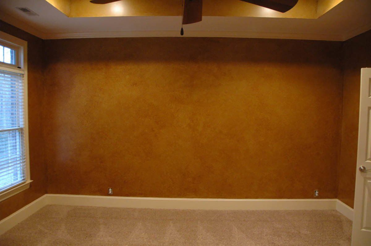 An empty room with a ceiling fan and a window