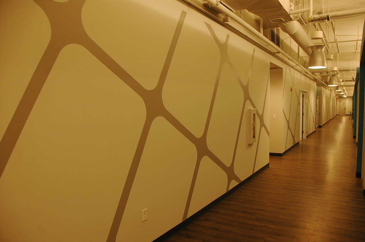 A long hallway with a geometric pattern on the wall.