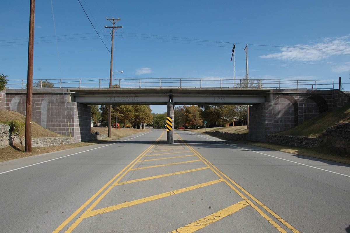 A bridge over a road with a blue sky in the background