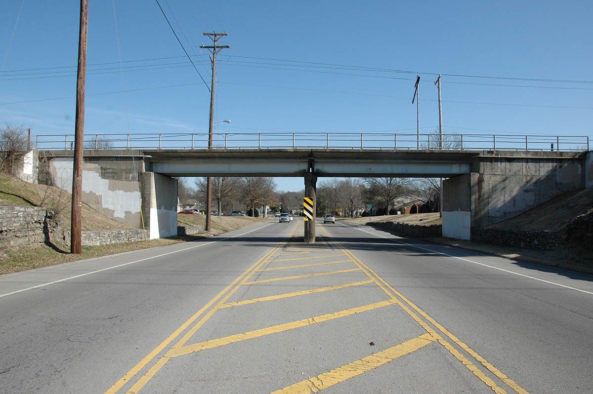 A bridge over a road with yellow lines on it