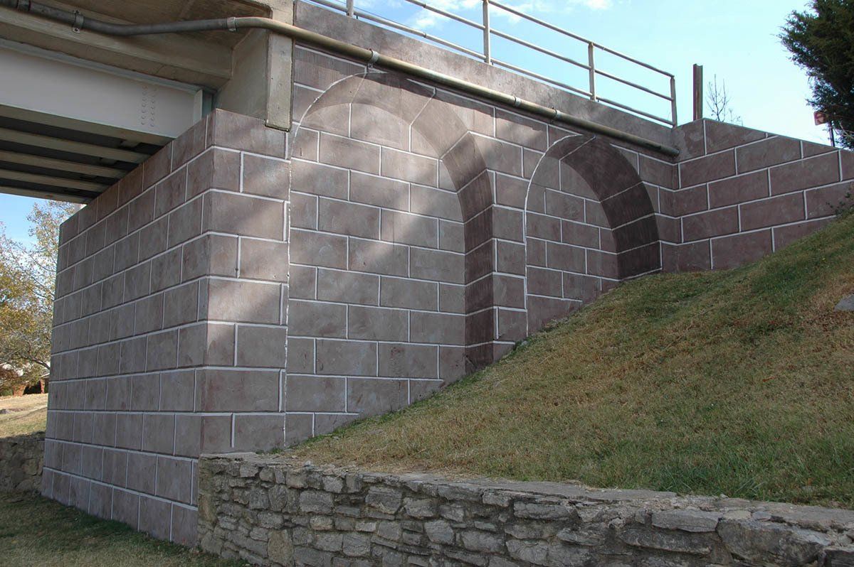A bridge with a brick wall underneath it.