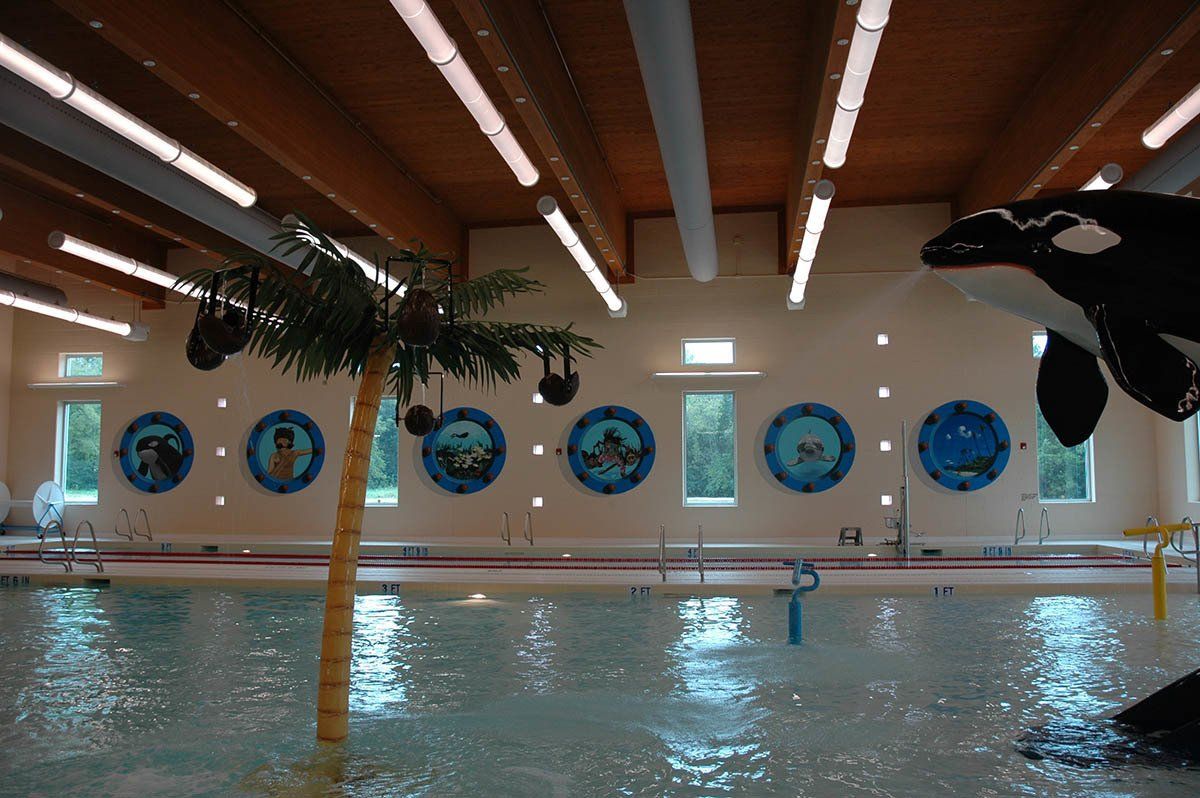 A swimming pool with a palm tree and a killer whale statue