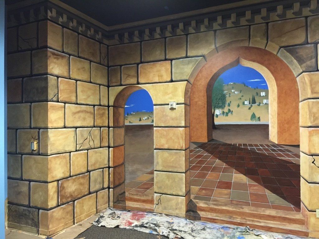 A painting of a brick wall with arches and stairs