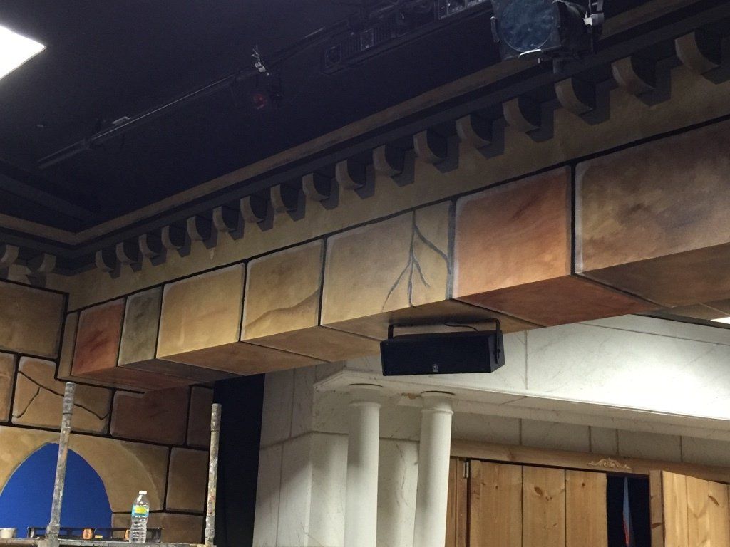 A room with a brick wall and a speaker on the ceiling