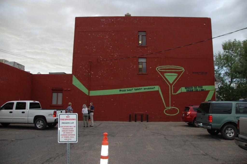 A white truck is parked in front of a red building