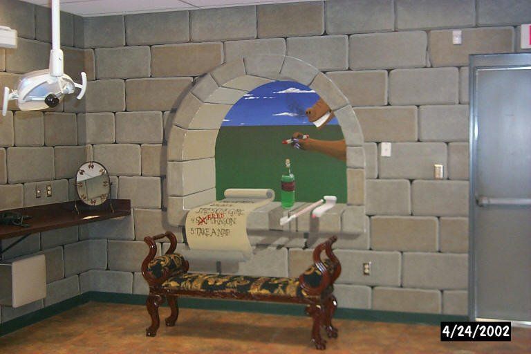 A room with a brick wall and a bench with a painting on it