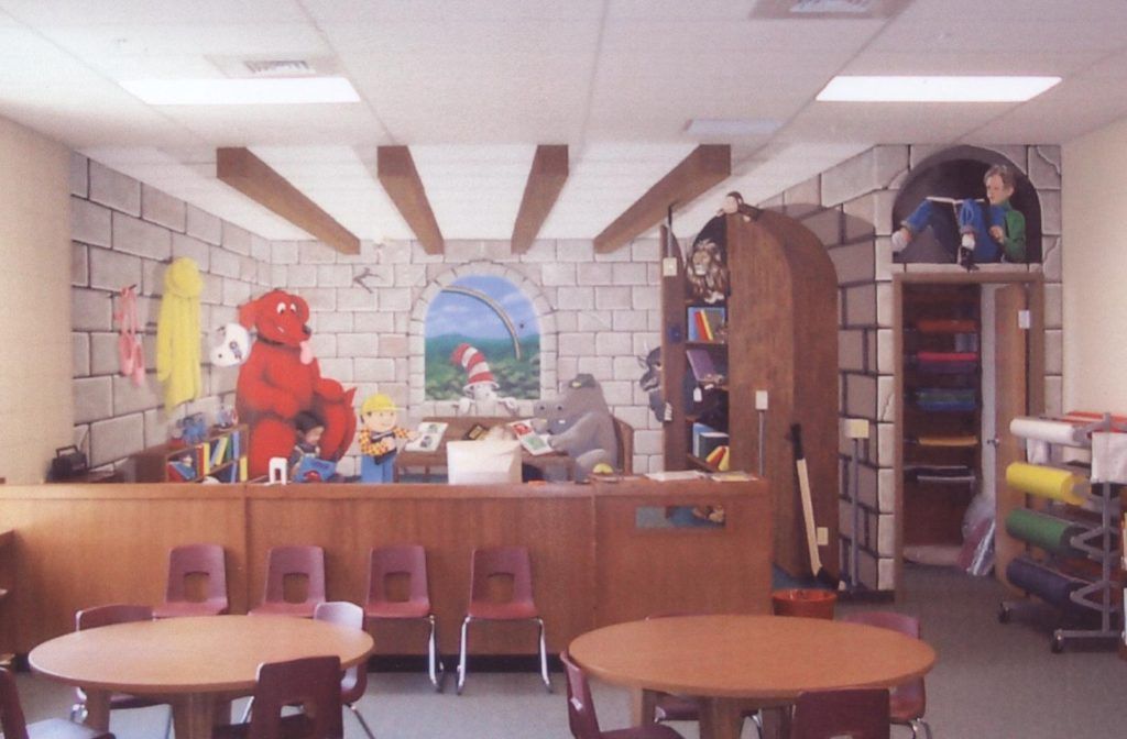A room with tables and chairs and a painting on the wall