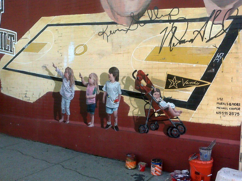 A mural of a basketball court is being painted on a wall