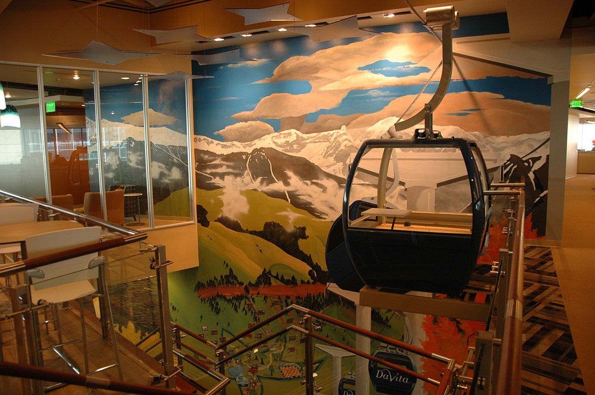 A ski lift with a painting on the wall behind it