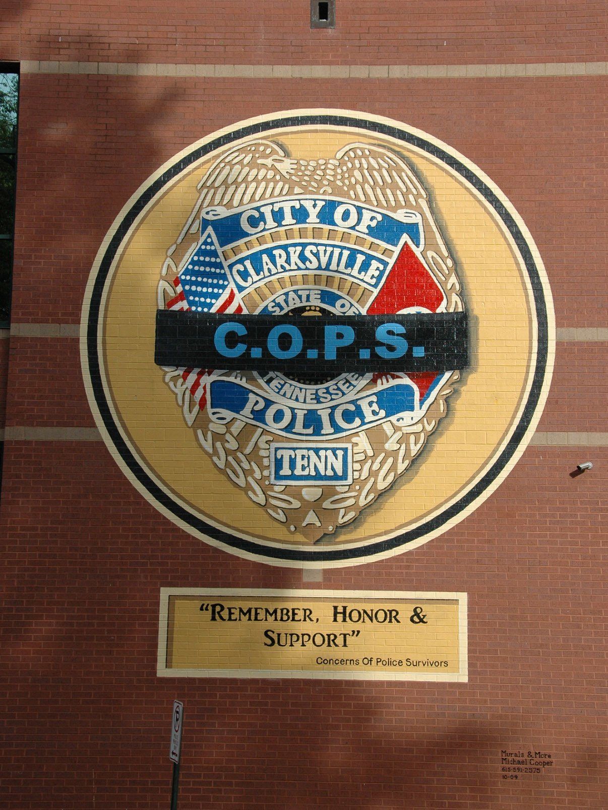 A city of clarksville c.o.p.s. police badge on a brick wall