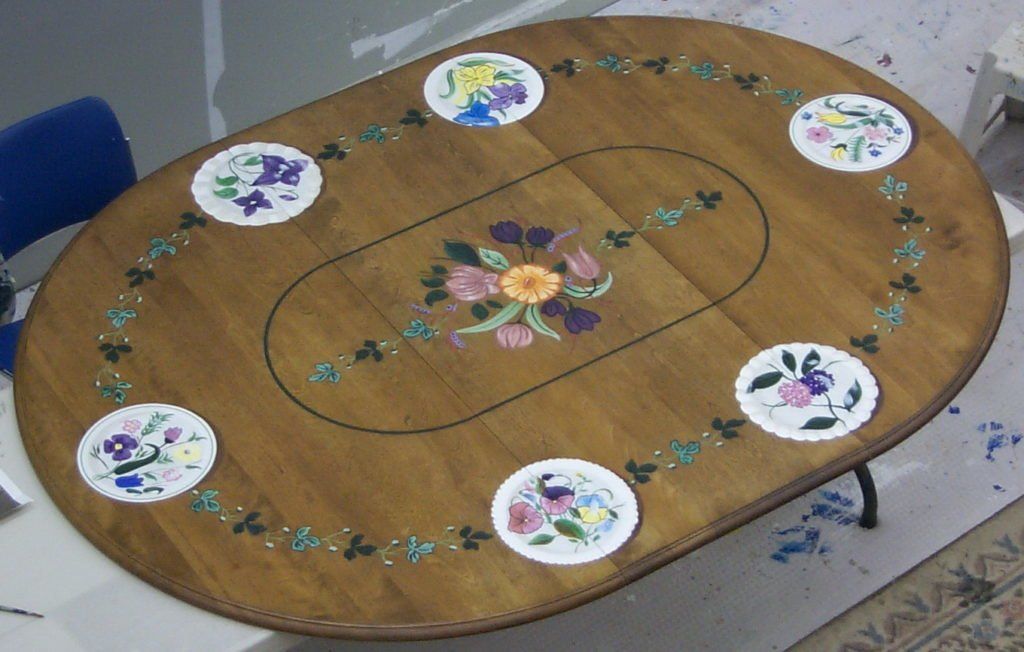 A wooden table with flowers painted on it