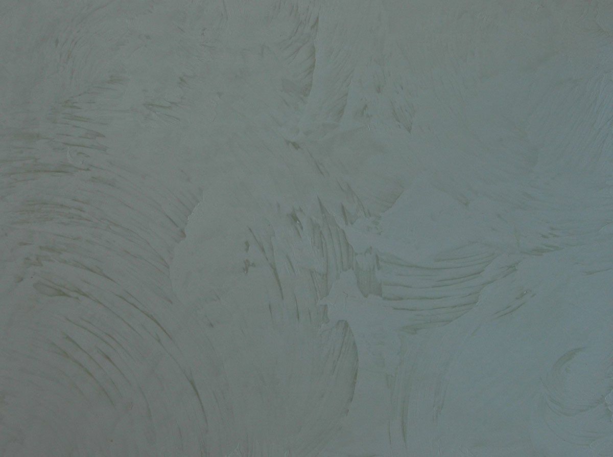 A close up of a white wall with a gray texture.