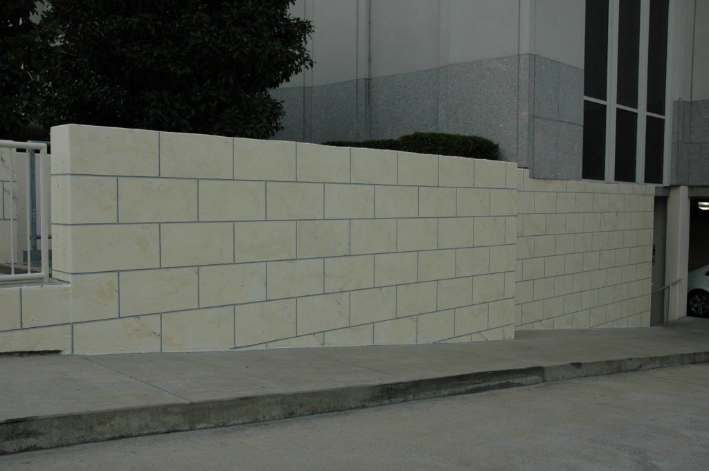 A large white brick wall with a few bricks missing