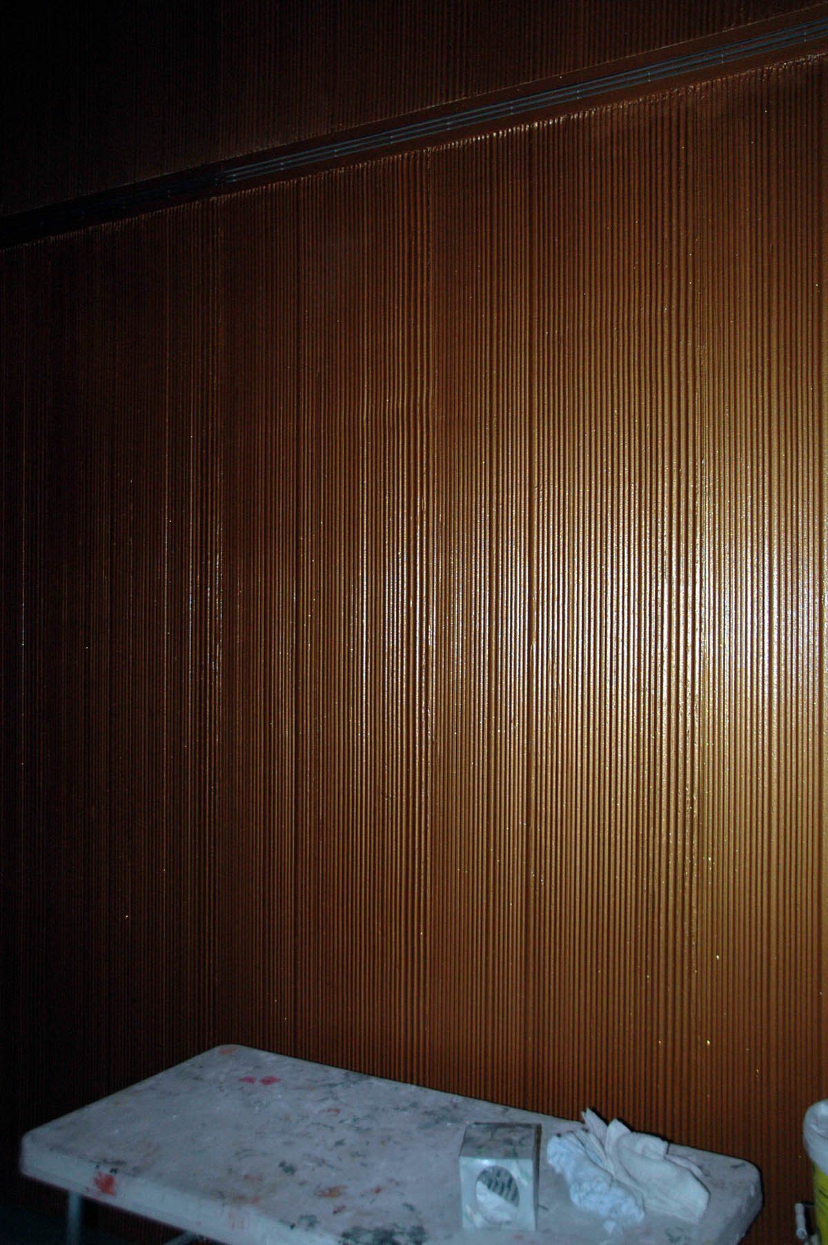 A wooden wall with a table in front of it.