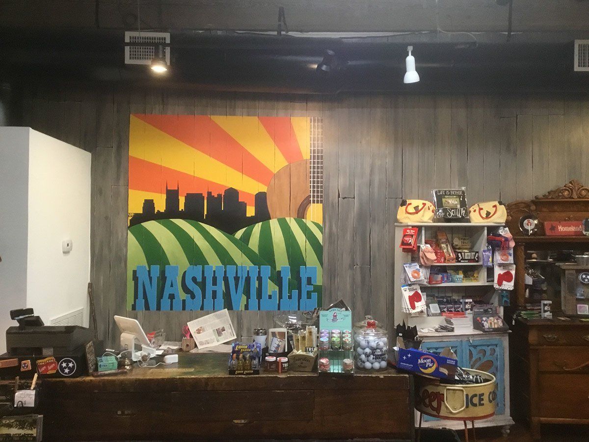 A store with a large painting of nashville on the wall