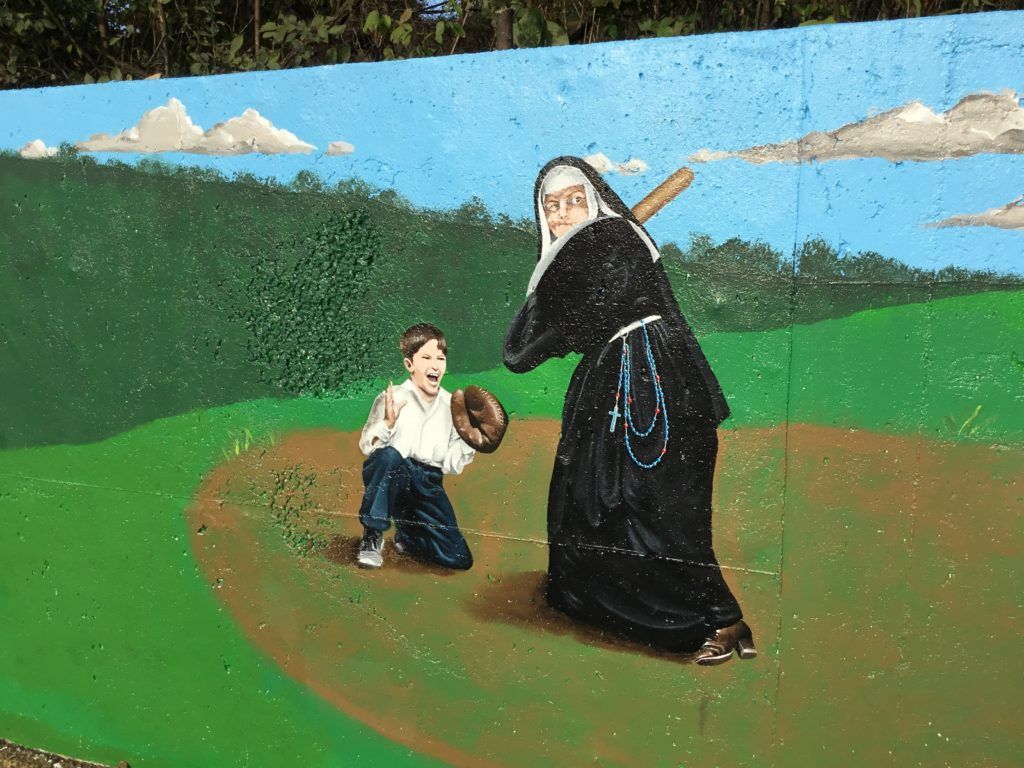 A painting of a nun playing baseball with a boy