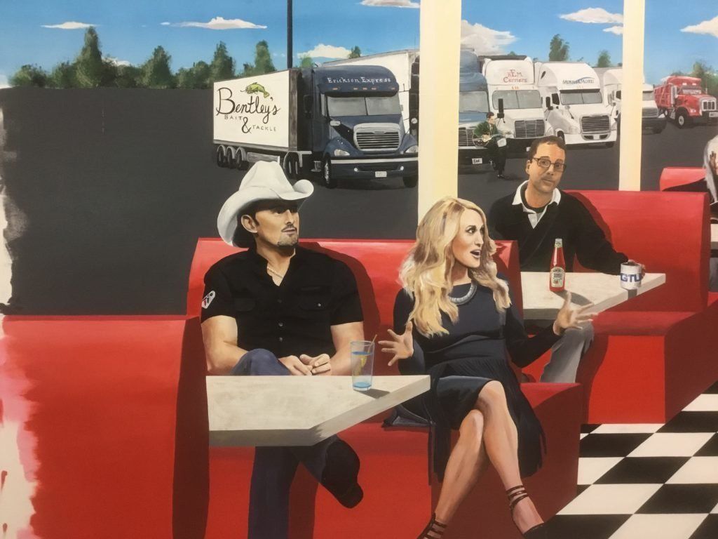A man in a cowboy hat sits next to a woman in a diner booth