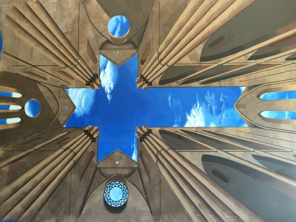 Looking up at a cross with a blue sky in the background