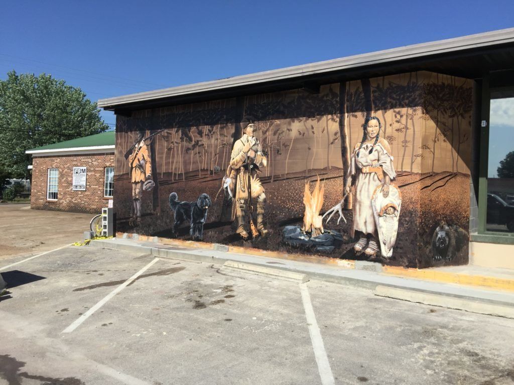 There is a large mural on the side of a building.