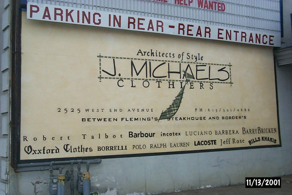 A billboard for j. michael 's clothes says parking in rear rear entrance