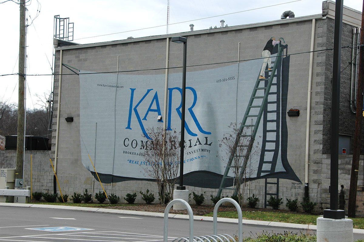 A large mural on the side of a building says karr commercial