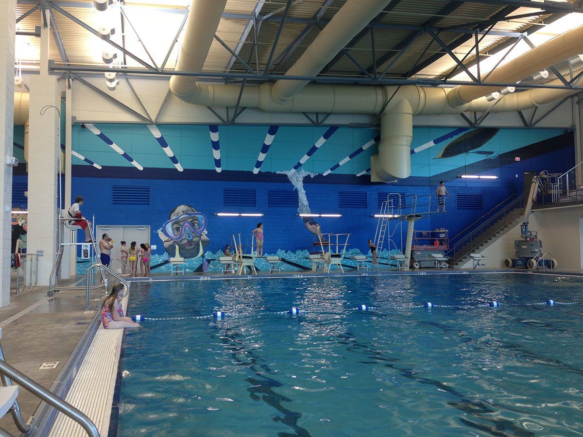 A large indoor swimming pool with people swimming in it