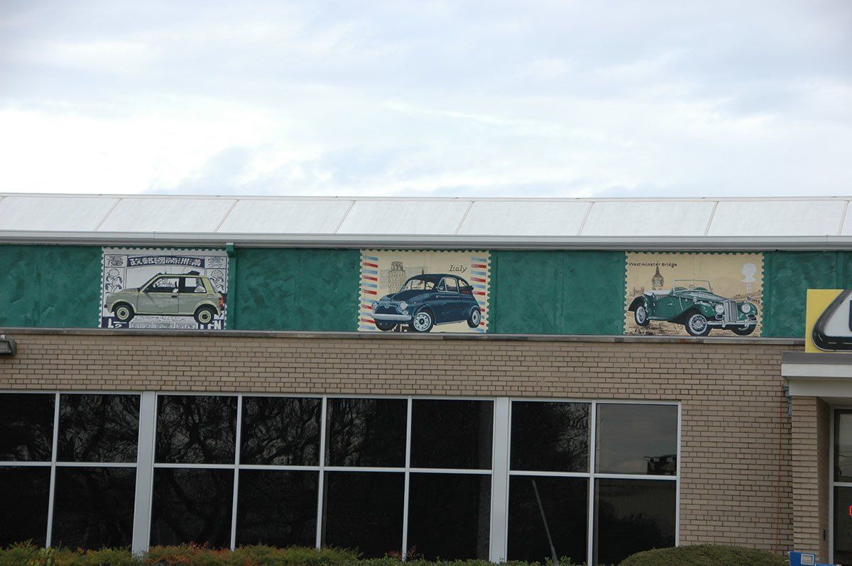 A brick building with cars painted on the side of it
