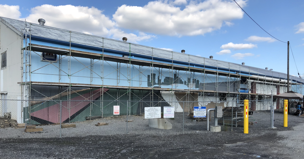 A large building is being built with scaffolding on the side of it.