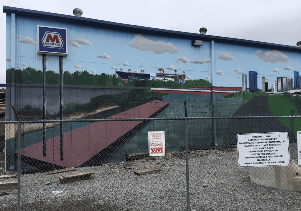 A large mural on the side of a building with the letter m on it