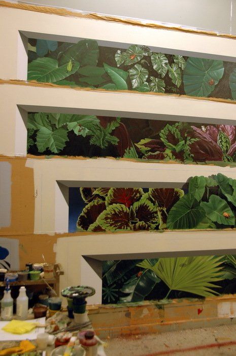 A painting of plants is being painted on a wall