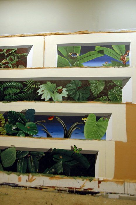 A painting of plants is being painted on a wall.