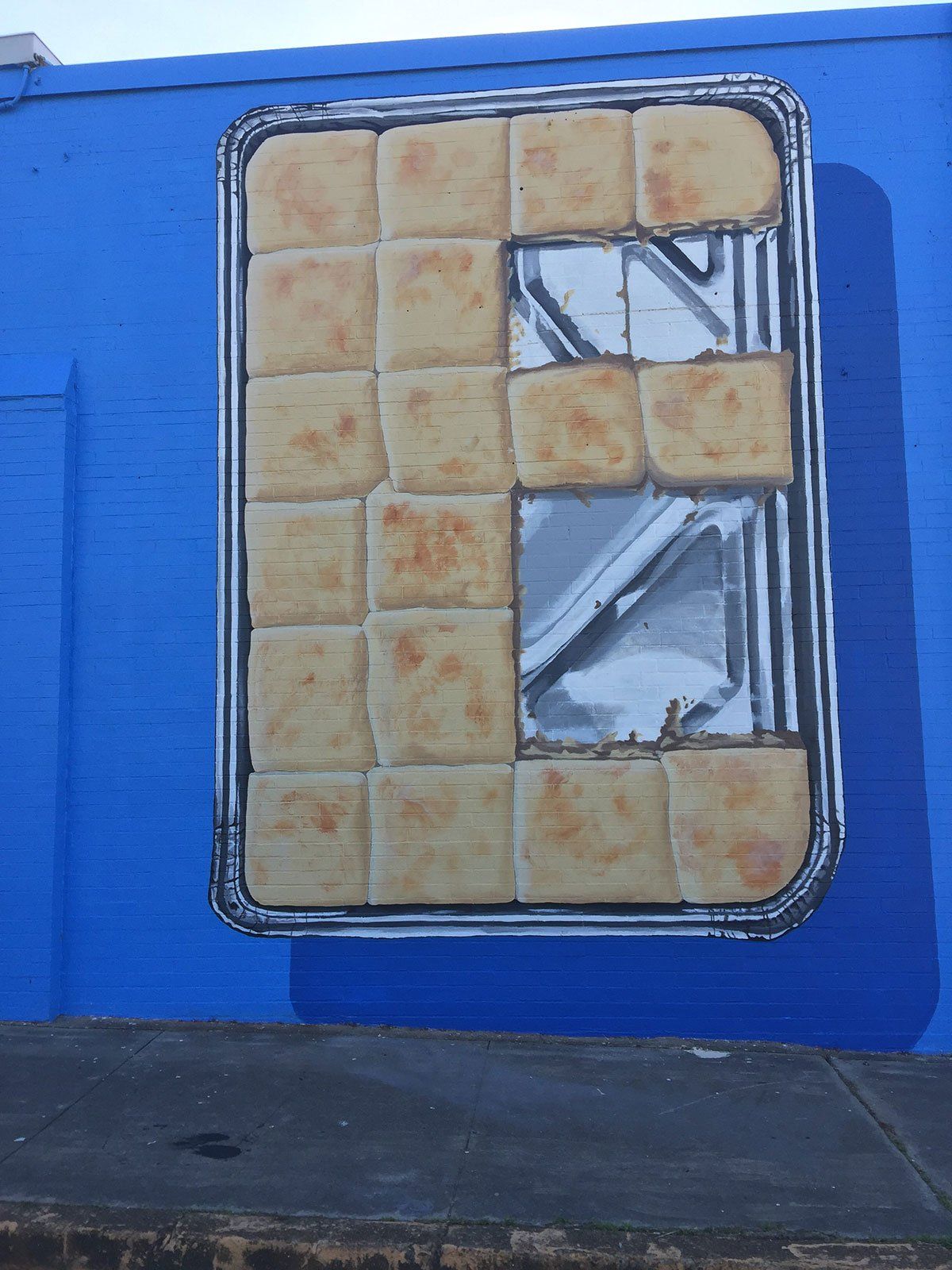 A blue wall with a tray of bread on it