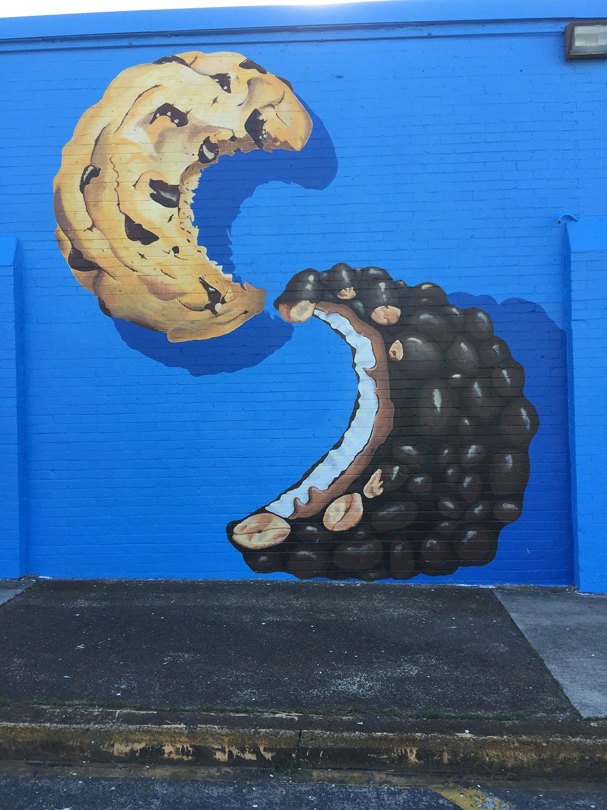 A painting of two cookies on a blue wall
