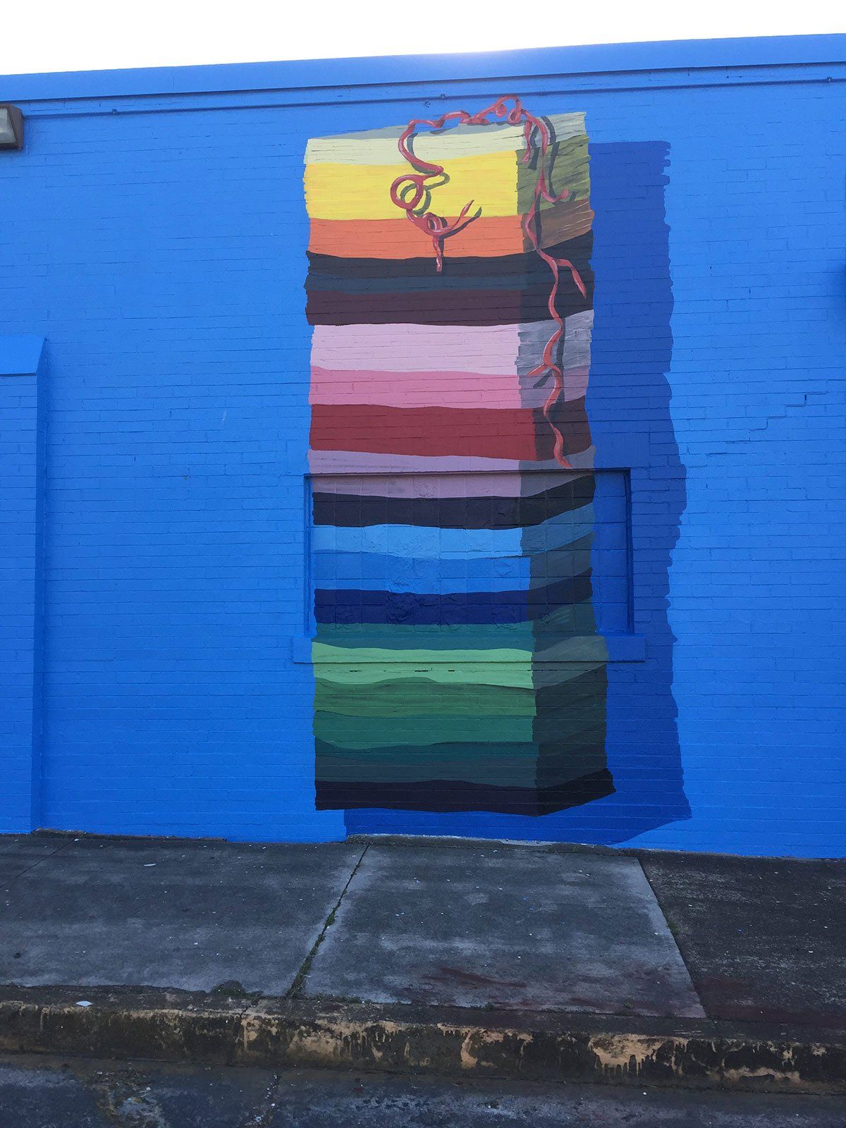 A blue wall with a colorful painting on it