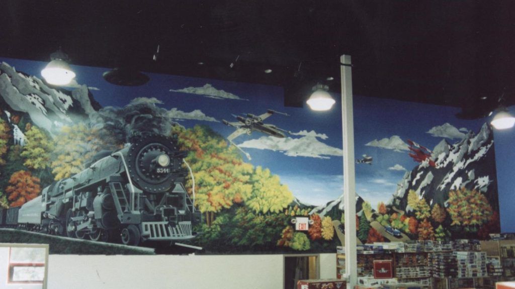 A painting of a train and mountains on a wall
