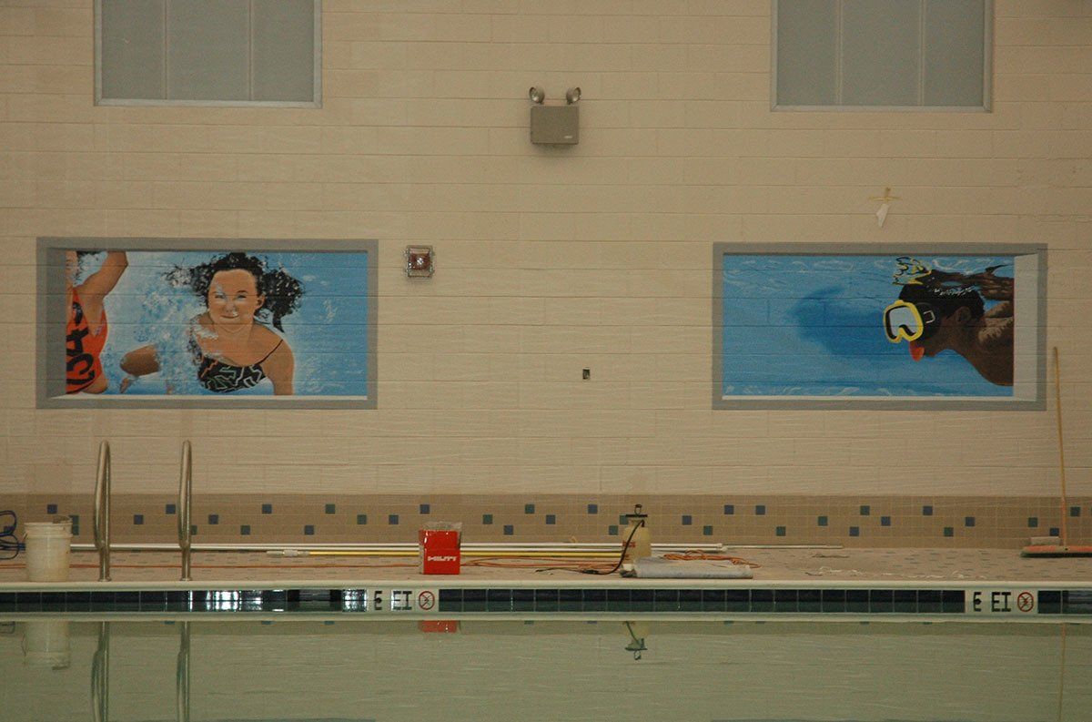 A swimming pool with a few paintings on the wall