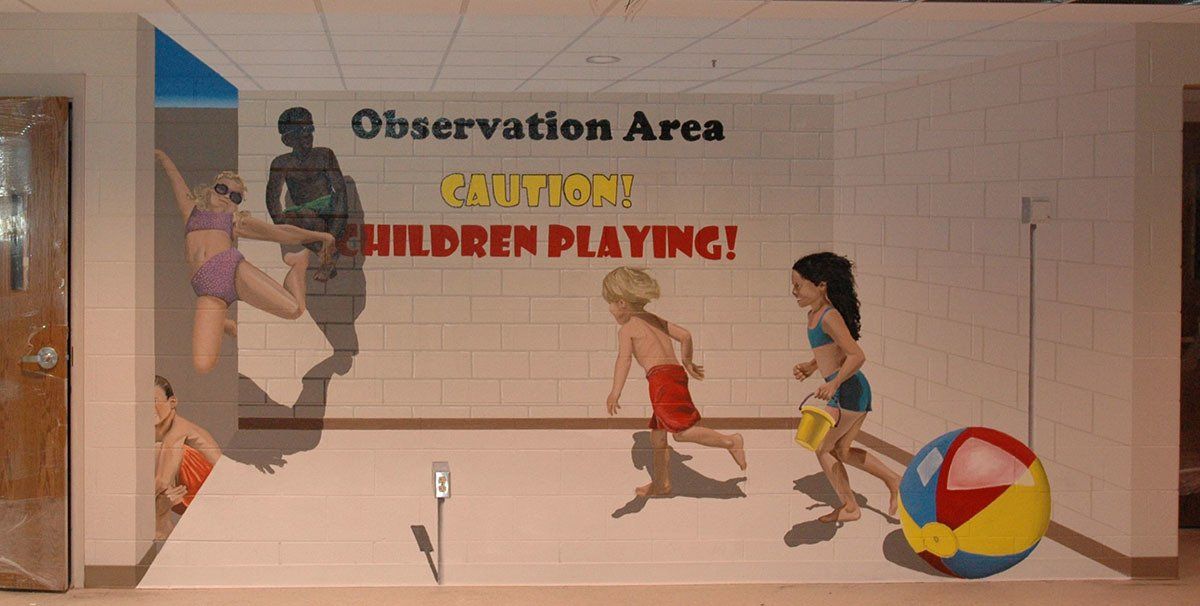 A mural on a wall that says observation area children playing
