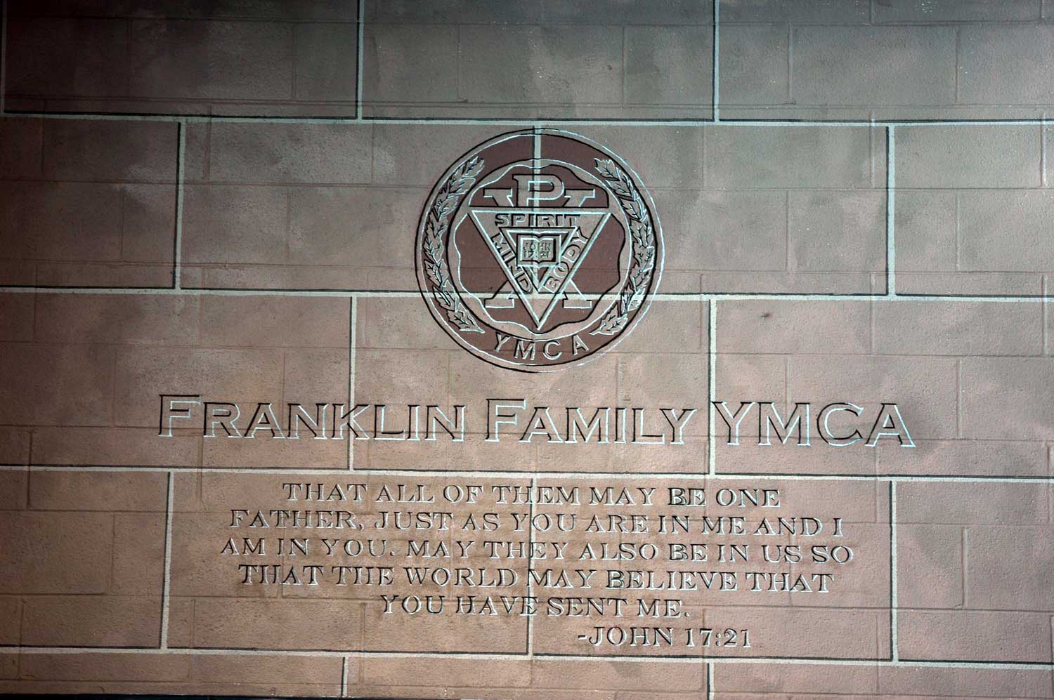 A plaque on a brick wall that says franklin family ymca