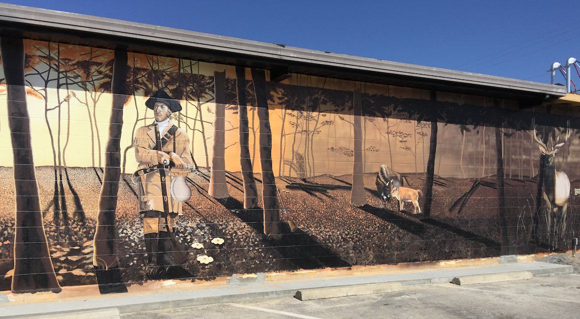 There is a large mural on the side of a building.