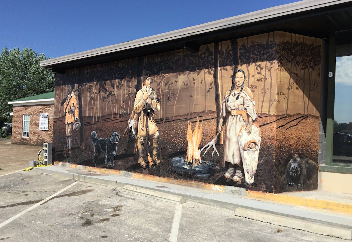 There is a large mural on the side of a building.